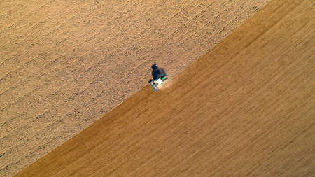 Aerial photo of a tractor ploughing a field in the french countrysideの写真素材