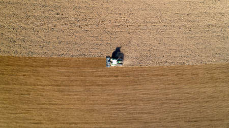 Aerial photo of a tractor ploughing a field in the french countrysideの写真素材