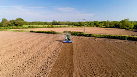 Aerial photo of a tractor ploughing a field in the french countrysideの写真素材