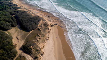 Aerial photo of two people walking on a wild beach in Vendee, Franceの写真素材