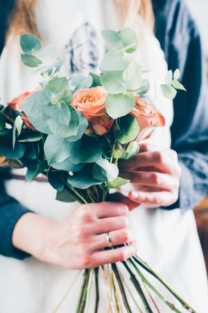 Florist woman making flower bouquet on her workplaceの写真素材