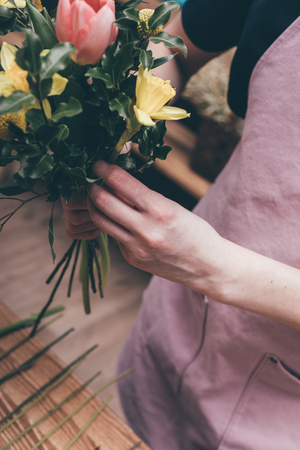 Florist making beautiful bouquet at flower shopの写真素材