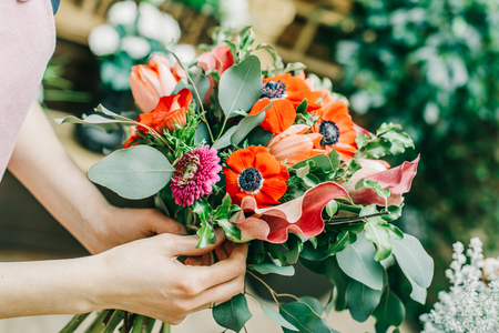 Florist making beautiful bouquet at flower shopの写真素材