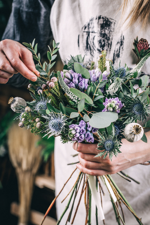 Own small business concept with woman florist working in modern flower shopの写真素材