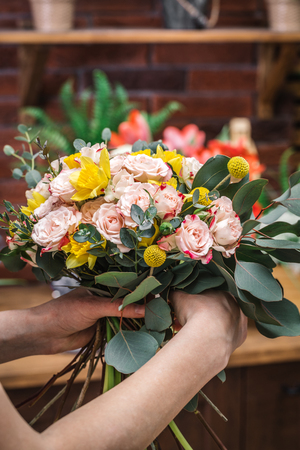 Crop person showing amazing tender floral composition in flower shop. の写真素材