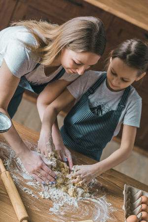 Young woman and daughter cookingの写真素材