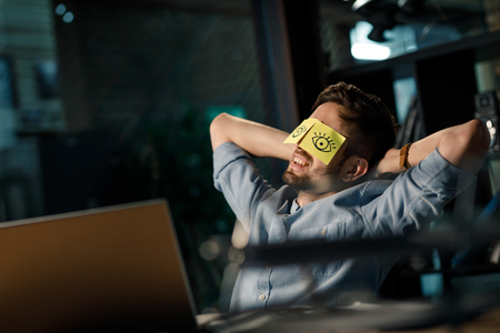Cheerful man with sticky notes on eyesの写真素材