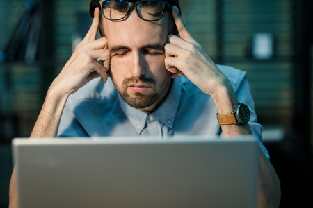 Worn out young man watching laptop