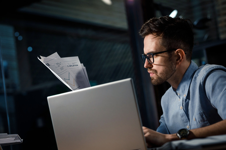 Overworked man with documents in officeの写真素材