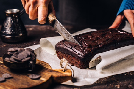 Woman cutting brown chocolate breadの写真素材