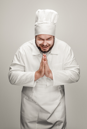 Cheerful chef clasping hands in gratitudeの写真素材