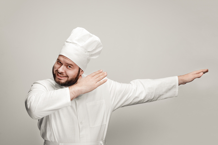 Cheerful chef dabbing and looking at cameraの写真素材