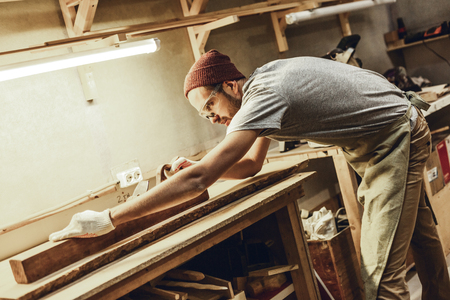 Man in goggles jointing plankの写真素材