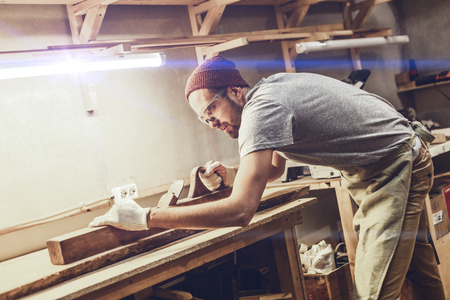 Focused carpenter jointing lumber boardの写真素材
