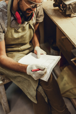 Crop craftsman sketching in notebookの写真素材