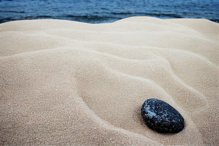 Black pebble stone on beach sand and sea water. Abstract summer coastline nature, vacation and travel background 3D render digital illustrationの素材