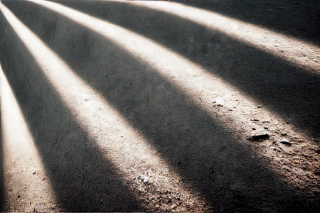 Streaks of sunlight on the textured concrete floorの素材