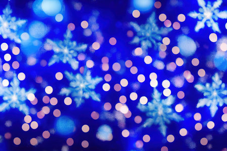 Christmas lights garlands and snowflakes on blue blurred backgroundの素材