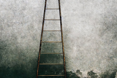 Large metal step ladder against wall of concrete grey houseの素材