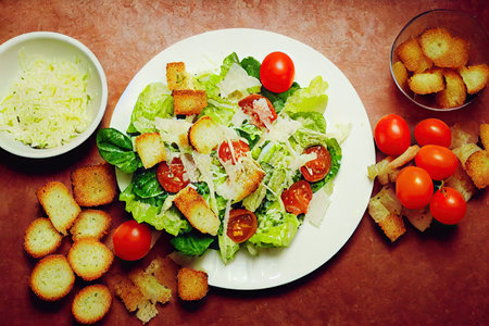 Bright fresh chicken caesar salad with red tomatoes and croutonsの素材