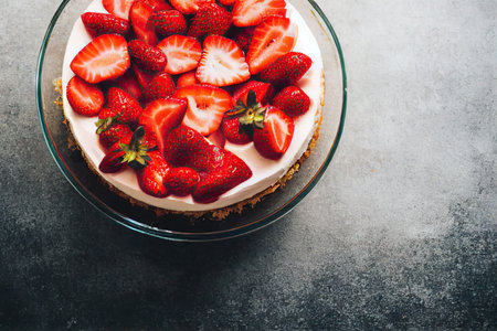 Large cheesecake with chopped bright red strawberriesの素材