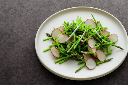 radish salad with asparagus potatoes and peas on plateの素材
