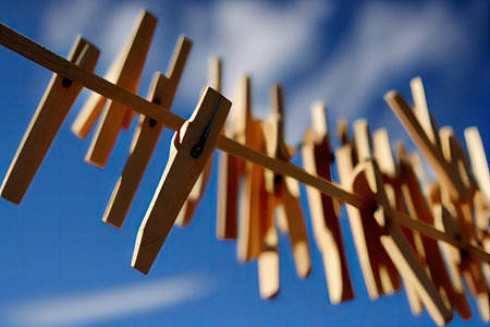 close-up of clothespins on a line, with the view of the blue sky in the background, created with generative aiの素材