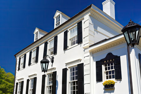 traditional white house with black shutters and lanterns against the blue sky, created with generative aiの素材