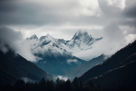 majestic mountain range shrouded in misty clouds, with snow-capped peaks visible, created with generative aiの素材