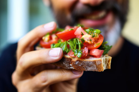 close-up of man eating vegan bruschettaの素材