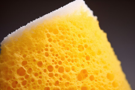 close-up of a yellow shower sponge with white foam on itの素材