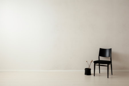 a white room with a single black chair against a clean wallの素材