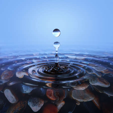 Drop of water falls on the transparent surface of the oceanの写真素材