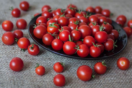 vintage cherry tomatoes on black plateの写真素材