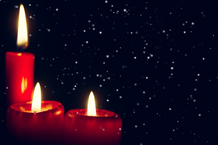 red candle with falling snowの写真素材