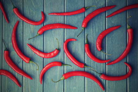 red chili peppers on a blue wooden backgroundの写真素材