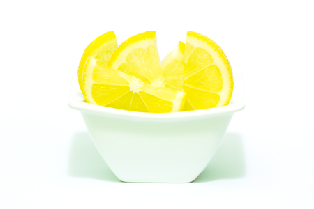 sliced lemons in a white bowlの写真素材