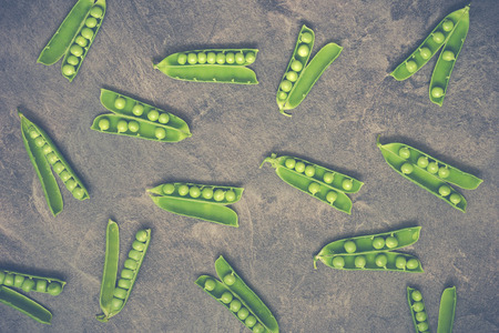 Green pea pods on a marble background