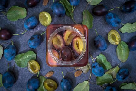 plum compote in a glass and green leavesの写真素材