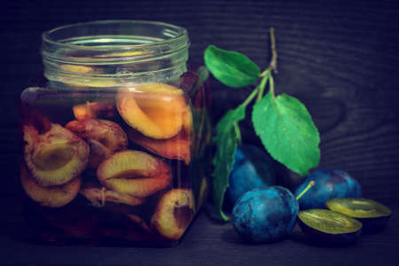 plum compote in a glass and green leavesの写真素材