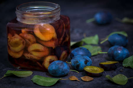 plum compote in a glass and green leavesの写真素材