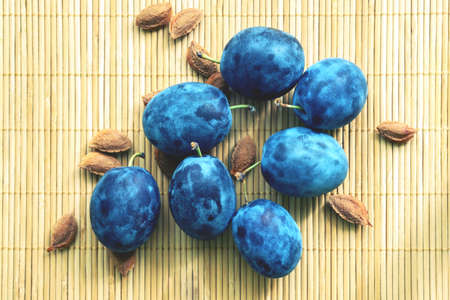 blue plums on a bamboo backgroundの写真素材
