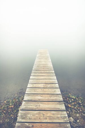 wooden pier at the foggy lakeの写真素材