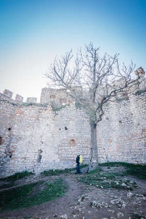 A man standing by the wall ruined castleの写真素材