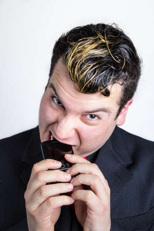 Businessman biting phoneの写真素材