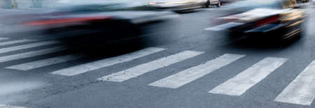 urban scene of cars running on pedestrian crossingの写真素材