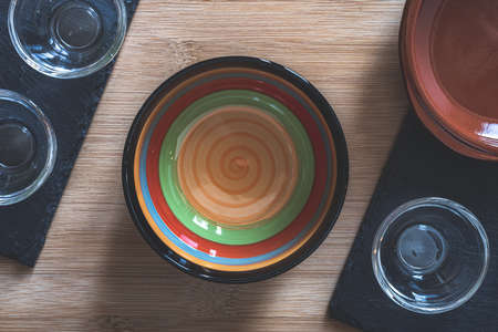 Angri, Italy. Empty ceramic and glass bowls and plates on a wooden cutting board and slate plates taken from above. Overhead shot. Props for Food Photography.の写真素材