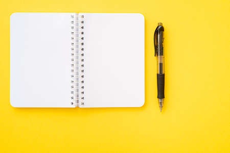 Notebook with ring binder with pen, isolated on yellow backdrop with copy space. Concept of writing.の写真素材