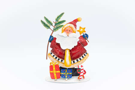 Handmade Santa Claus figure made of tin with gifts placed at his feet with planty of copy space on the side.の写真素材