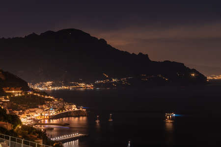 Amalfi, Italy. September 4th, 2020. Enchanting night view on the town of Amalfi and the Amalfi Coast with street lights and boats at sea.のeditorial素材